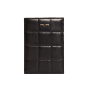 A sleek, designer passport holder for women who love to travel, made of high-quality leather in a black with a gold embossed logo on the front, featuring organized compartments for travel documents and credit cards.