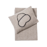 A luxurious men's cashmere blanket, pillow, and eye mask set featured in a gift guide for luxury designer gifts for men, perfect for traveling in style.