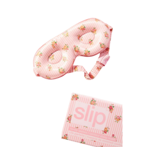 A soft, luxurious pink silk eye mask with a smooth, glossy finish, perfect as a stylish and cozy gift for women who travel.